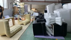 Production area with various upholstered items mid-assembly, ready for final finishing.
