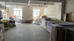 Interior of a furniture factory showing upholstery stations, tools, and semi-finished products.