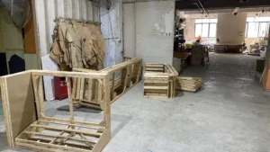 Interior of a furniture factory showing upholstery stations, tools, and semi-finished products.