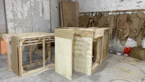 Production area with various upholstered items mid-assembly, ready for final finishing.