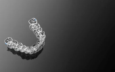 Single clear aligner displayed against a dark background highlighting clarity and shape.